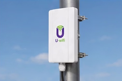 Outdoor U-wifi gateway attached to a metal pole with brackets under a clear blue sky.