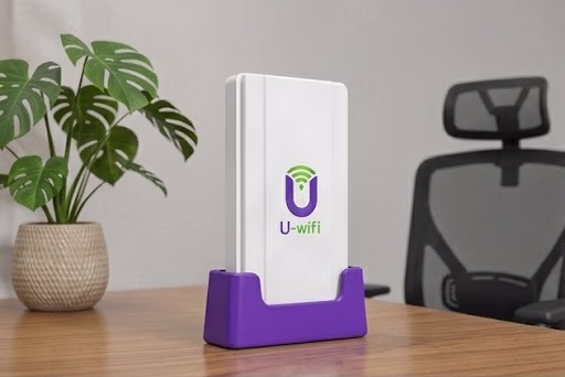 White U-wifi gateway device placed on a purple desktop stand in an office environment.